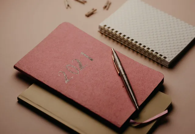 Notebooks and a pen arranged on a table