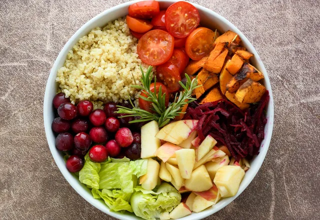 A bowl of quinoa, fruit and fresh vegetables