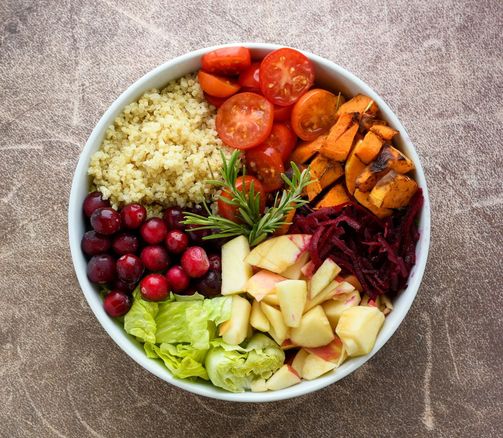 A bowl of quinoa, fruit and fresh vegetables