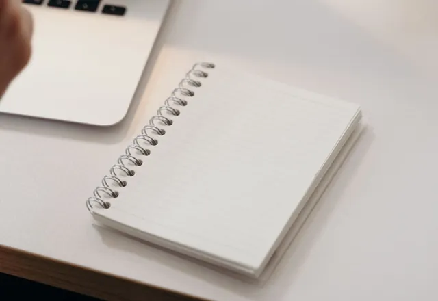 A notebook and laptop on a desk
