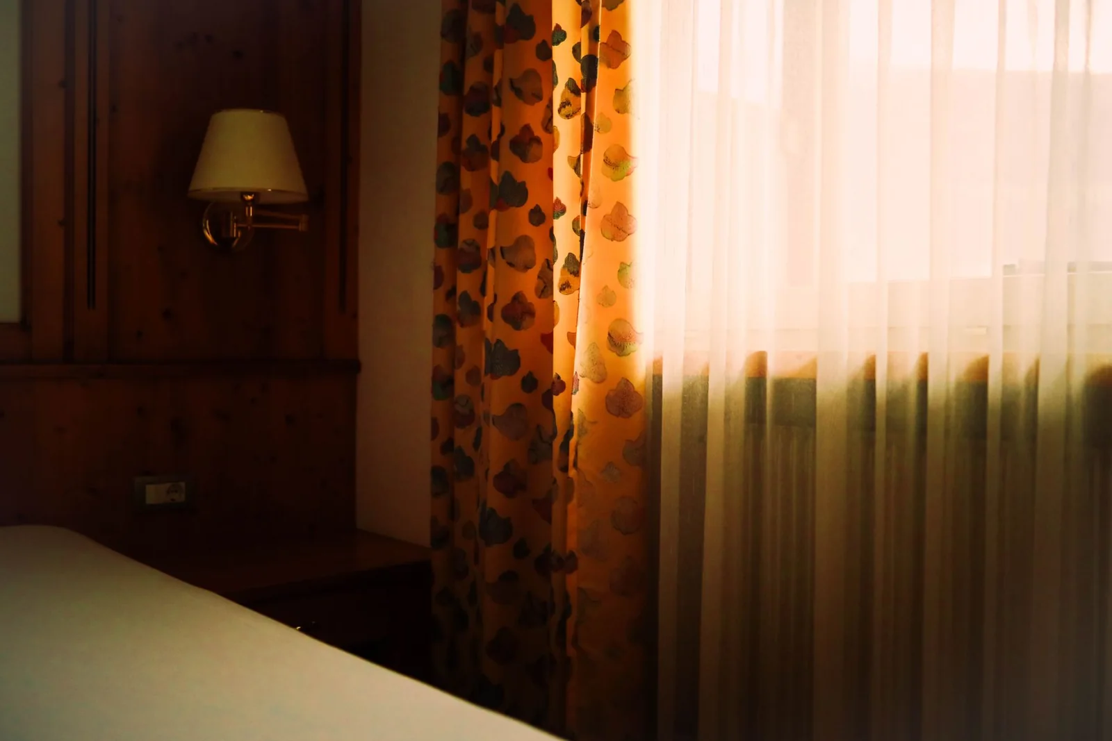 A bedroom with soft light through the curtains