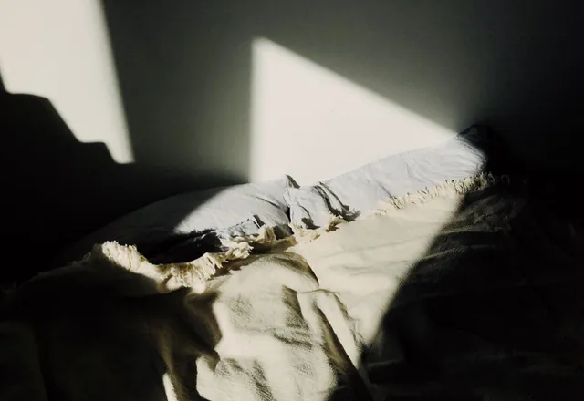 Sunlight falling across a bed and blanket